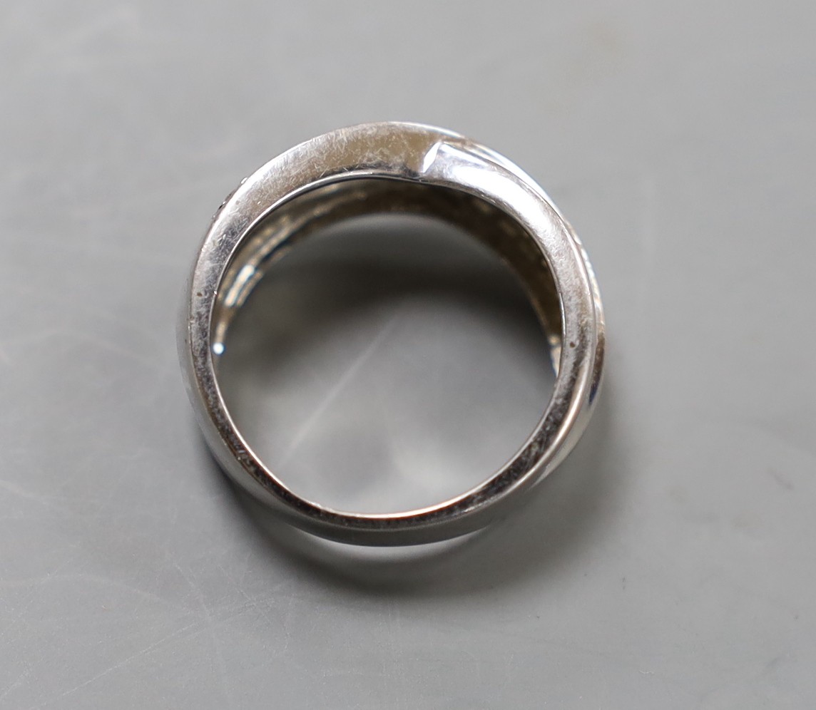 A modern 14k white metal and three row diamond chip set crossover ring, size N, gross weight 5.8 grams.